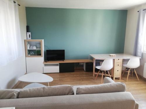 a living room with a couch and a table at Jolie petite maison indépendante de plain-pied in Pont-de-Buis