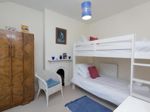 a bedroom with two bunk beds and a fireplace at Pass the Keys Comfortable Stone Built Cottage in Menai Bridge in Menai Bridge