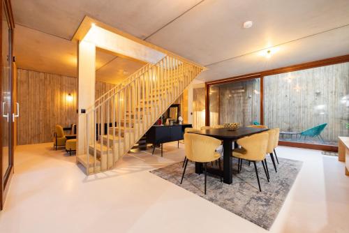 a dining room with a table and chairs and a staircase at The Victoria Park Sanctuary - Stunning 2BDR Flat in London