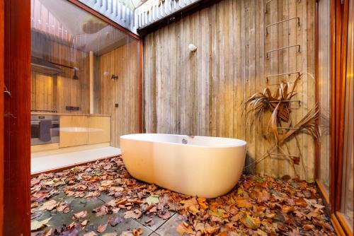 a bathroom with a tub with leaves on the floor at The Victoria Park Sanctuary - Stunning 2BDR Flat in London