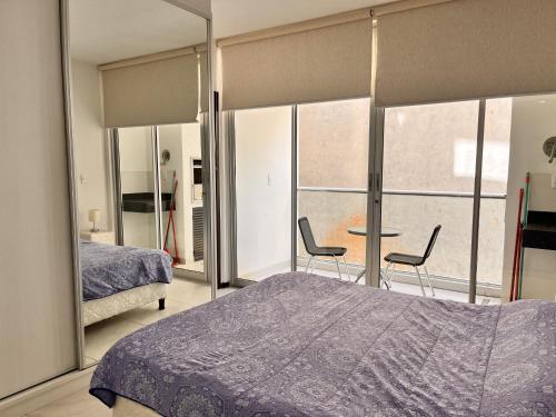 1 dormitorio con 1 cama, mesa y sillas en Departamento 1 habitación zona exclusiva, en Asunción