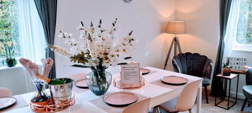 a dining room table with a vase of flowers on it at Sunny-side-up in St Austell
