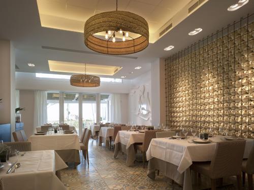 a restaurant with white tables and chairs and a wall at Hotel Boutique Balandret in Valencia