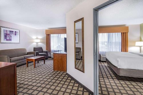 a hotel room with a bed and a living room at Baymont by Wyndham Gurnee in Gurnee