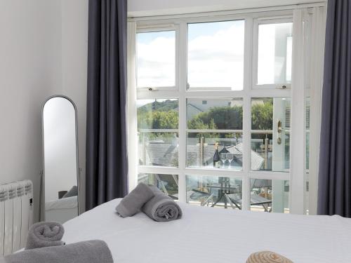 a bedroom with a bed and a large window at Pass the Keys 2 Bed Sea View Apartment with Balcony Parking in Benllech