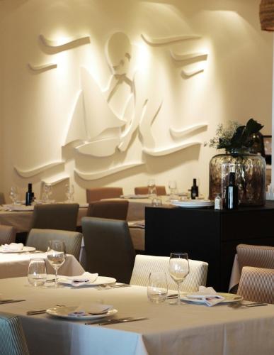 a dining room with white tables and chairs and a wall at Hotel Boutique Balandret in Valencia