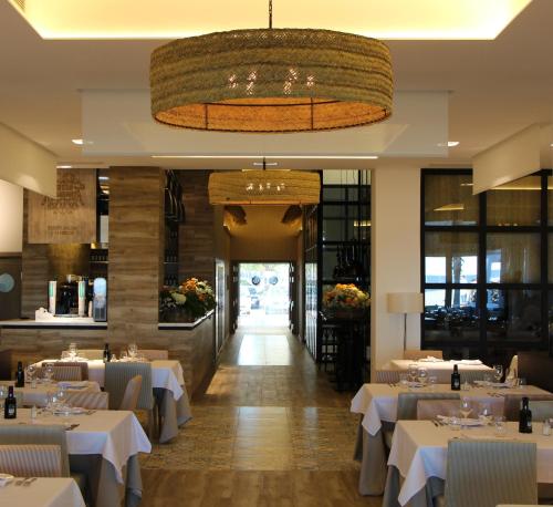 a dining room with white tables and a chandelier at Hotel Boutique Balandret in Valencia
