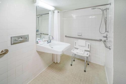 a white bathroom with a sink and a shower at Days Inn by Wyndham Del Rio in Del Rio