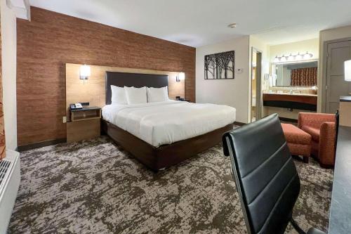 Habitación de hotel con cama y silla en Maine Evergreen Hotel, Ascend Hotel Collection en Augusta