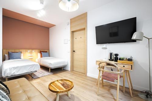 Habitación de hotel con cama y TV en la pared en Vallecas Suites by Olala Homes, en Madrid