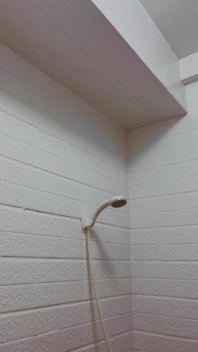 a shower with a hose in a bathroom at South Talk B&B in Hengchun