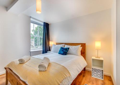 a bedroom with a large bed and a window at Greyhound Cottage in Kendal