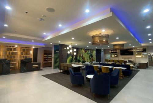 une salle à manger avec des tables et des chaises bleues dans l'établissement La Quinta Inn & Suites by Wyndham Galt Lodi North, à Galt