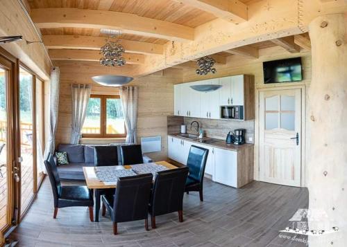 a kitchen and dining room with a table and chairs at DOMEK POD LIMBAMI IV in Kluszkowce