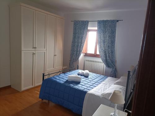 a bedroom with a blue and white bed with a window at Appartamenti Santa Chiara in Assisi