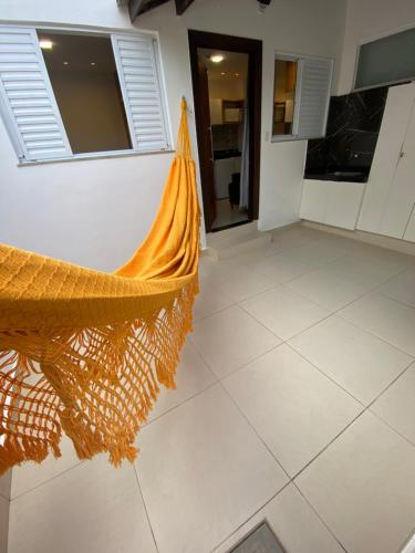 a hammock in a room with a kitchen at Recanto Novo Premium Flat in Cabo Frio