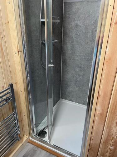 a shower with a glass door in a bathroom at Glamping Pods in Milngavie