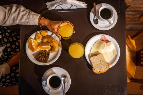 a table topped with plates of breakfast foods and coffee at Kau Kaleshen in El Calafate
