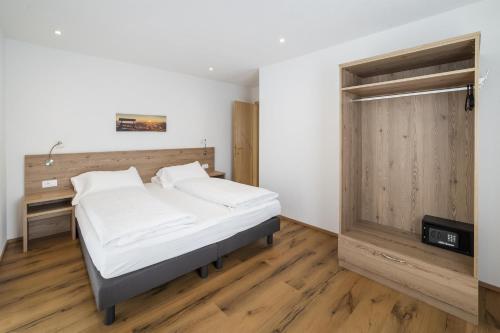 a bedroom with a bed and a wooden door at Apartments Gasser in Rasun di Sopra