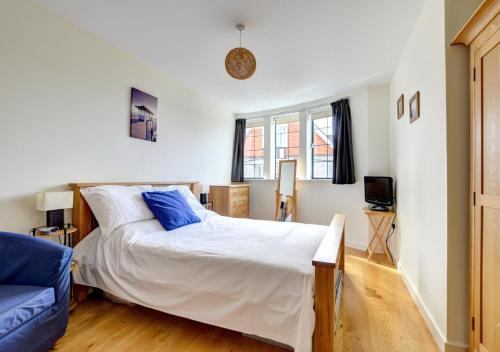a bedroom with a bed and a blue couch at Flat 8 Broadleys in Swanage