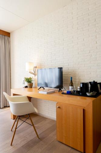a desk with a computer and a chair on it at Hotel de Milliano in Breskens