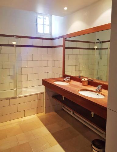 une salle de bain avec deux lavabos, un miroir et une baignoire dans l'établissement Bel appartement à la Chetardière, à Sainte-Gemme-dʼAndigné