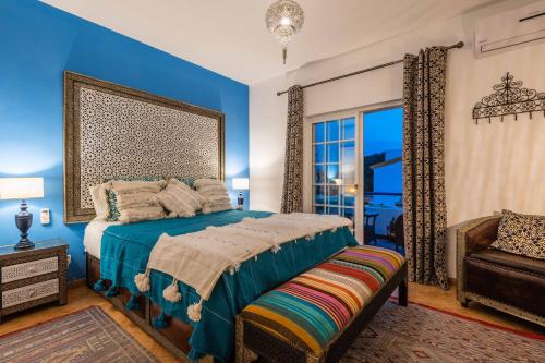 a bedroom with blue walls and a bed and a chair at Villa Oasis Galé - Luxury Villa with private pool, AC, free wifi, 5 min from the beach in Albufeira