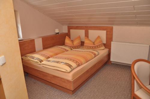 a bedroom with a large wooden bed with pillows at Cafe Hoyer Pension und Appartements in Rödigsdorf