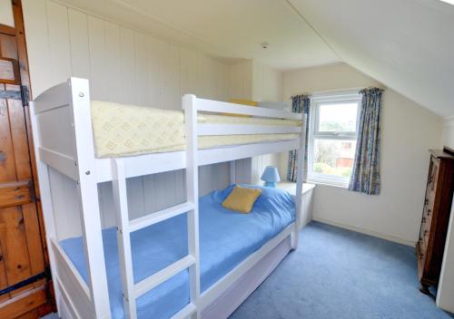 a bedroom with two bunk beds in a house at Cornerways in Worth Matravers