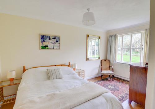 a bedroom with a large white bed and a window at Wild Hill in Worth Matravers