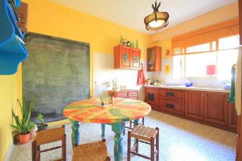 a kitchen with a table with chairs and a chalkboard at Boho Hostel in St. Julianʼs
