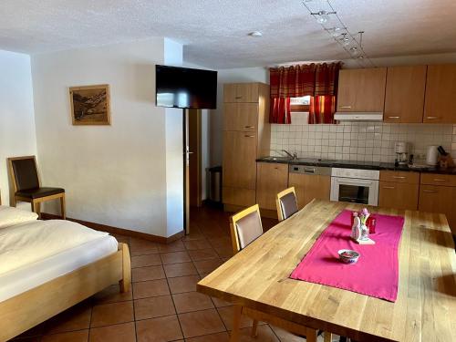 uma cozinha e sala de jantar com uma mesa e uma cama em Appartements Kröll em Saalbach-Hinterglemm