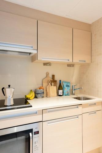 a kitchen with white cabinets and a sink at Hotel de Milliano in Breskens