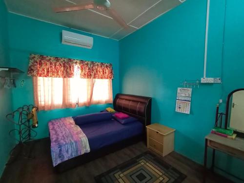 a bedroom with a bed and a blue wall at Hazaff Homestay in Sungai Petani