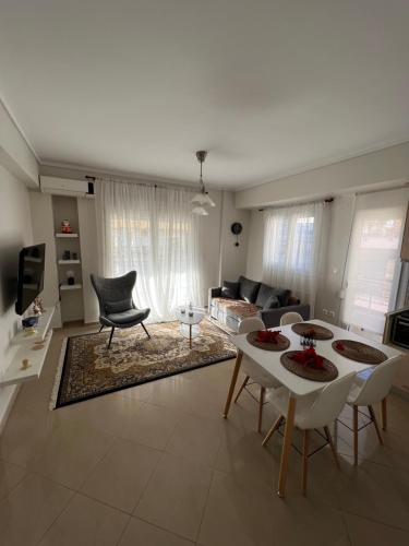 a living room with a couch and a table and chairs at SilverLine Comfort Apartment in Thessaloniki
