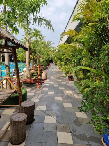 a resort walkway with trees and benches and the water at STAY SWEET in Phnom Penh