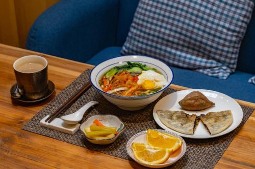 a table with a bowl of soup and a bowl of food at Mild Spring Boutique Hotel in Huangshan