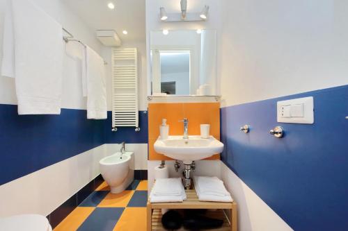 baño azul y blanco con lavabo y aseo en Sweet home near colosseo en Roma