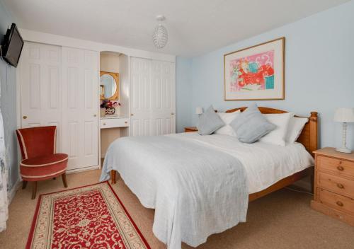 a bedroom with a large white bed and a chair at Little Doric in Woodbridge