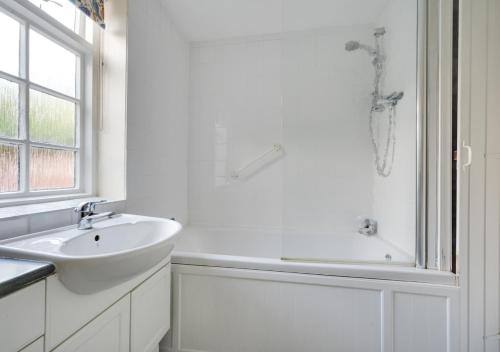 Baño blanco con bañera y lavamanos en Little Doric, en Woodbridge