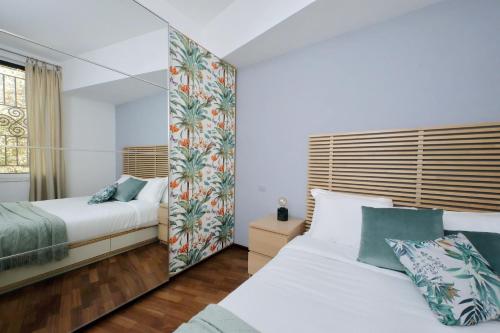 1 dormitorio con 2 camas y espejo en Sweet home near colosseo en Roma
