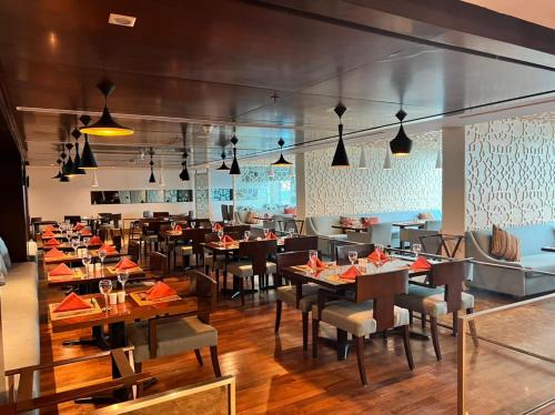 a dining room with tables and chairs in a restaurant at Copthorne Hotel Sharjah in Sharjah
