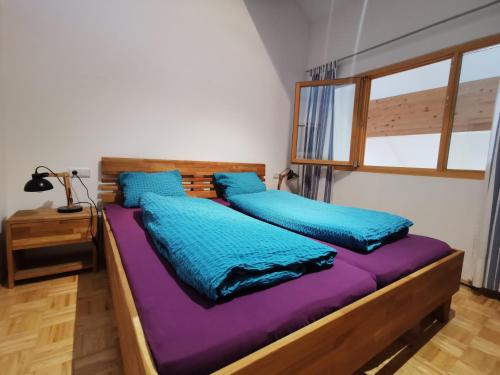 2 camas en una habitación con sábanas azules y moradas en Apartment Bergführer, en Warth am Arlberg