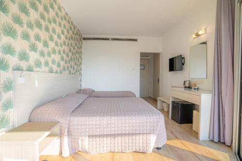 a small bedroom with a bed and a desk at Harmony Bay Hotel in Limassol