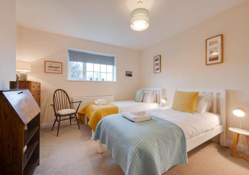 ein Schlafzimmer mit 2 Betten und einem Stuhl darin in der Unterkunft Marlon House in Southwold