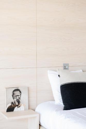 a bedroom with a bed with a black and white photo on a table at Hotel de Milliano in Breskens