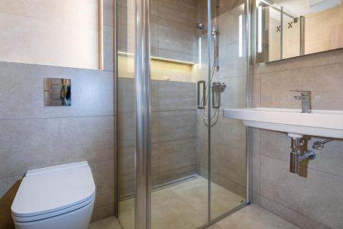La salle de bains est pourvue d'une douche, de toilettes et d'un lavabo. dans l'établissement TATRYSTAY Hillside Apartments, à Dolný Kubín