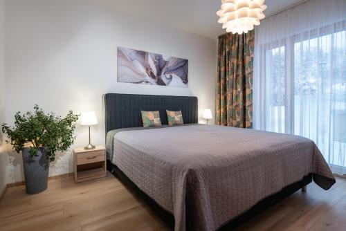 - une chambre avec un lit et une grande fenêtre dans l'établissement TATRYSTAY Hillside Apartments, à Dolný Kubín