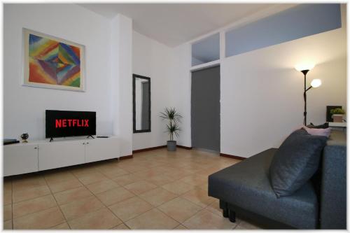 a living room with a couch and a tv at [10 min metro] Palavela Suite in Turin