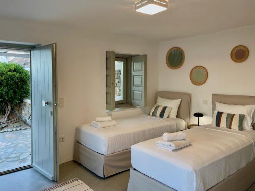 two beds in a room with a mirror at Bohemian Blue Villa - 7 BDRM - beach in 200m - MG Villas in Panormos Mykonos